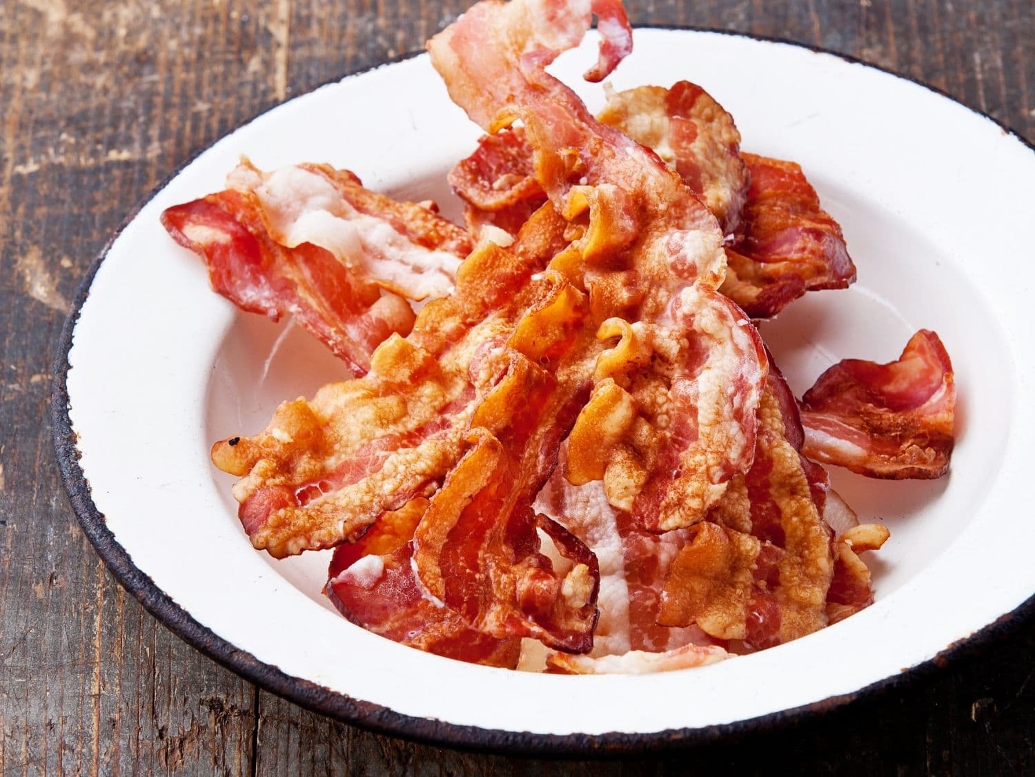 slices of cooked bacon on a white plate.